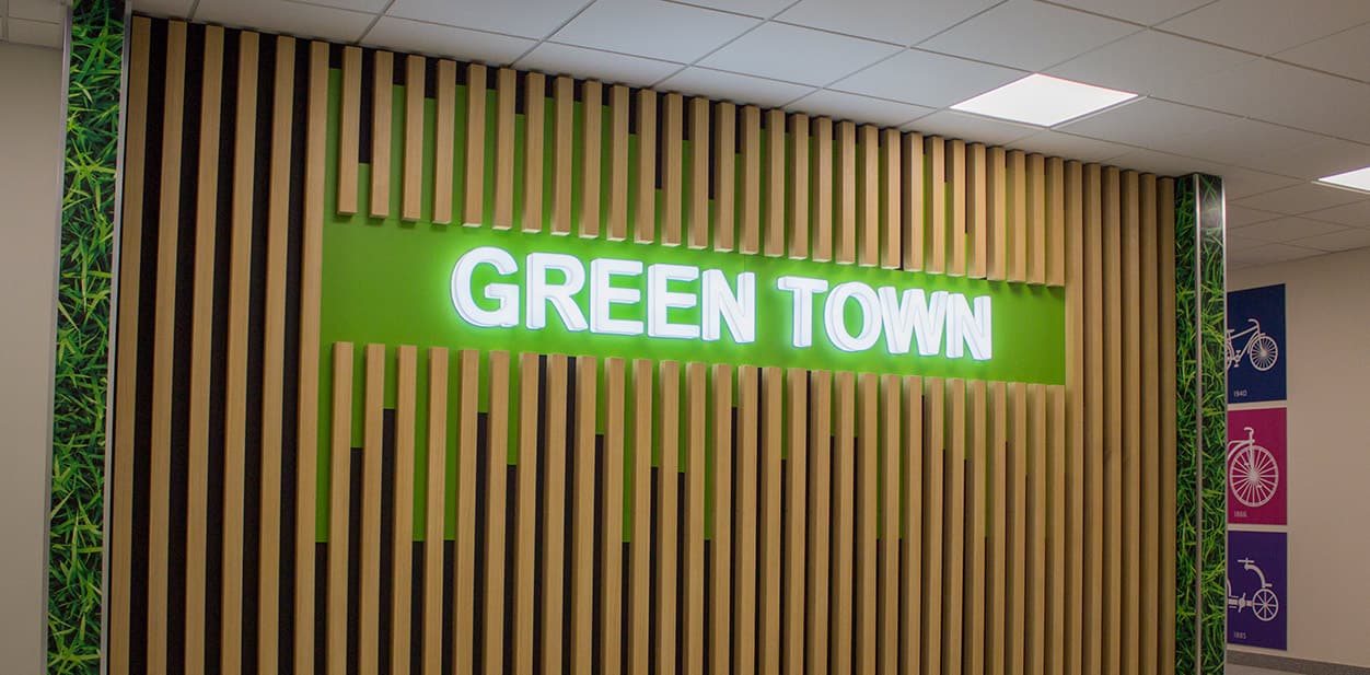 Green Town light up wall art featuring the brand name on the wood and green display