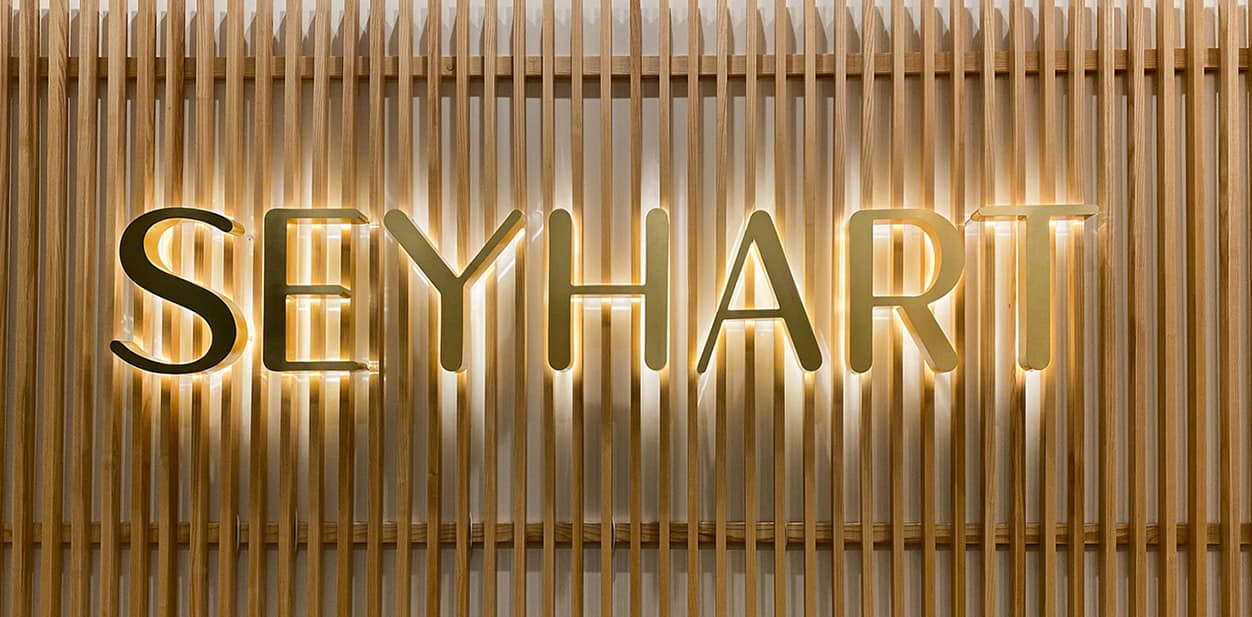 Seyhart lighted wood wall art with gold letters featuring the company's name