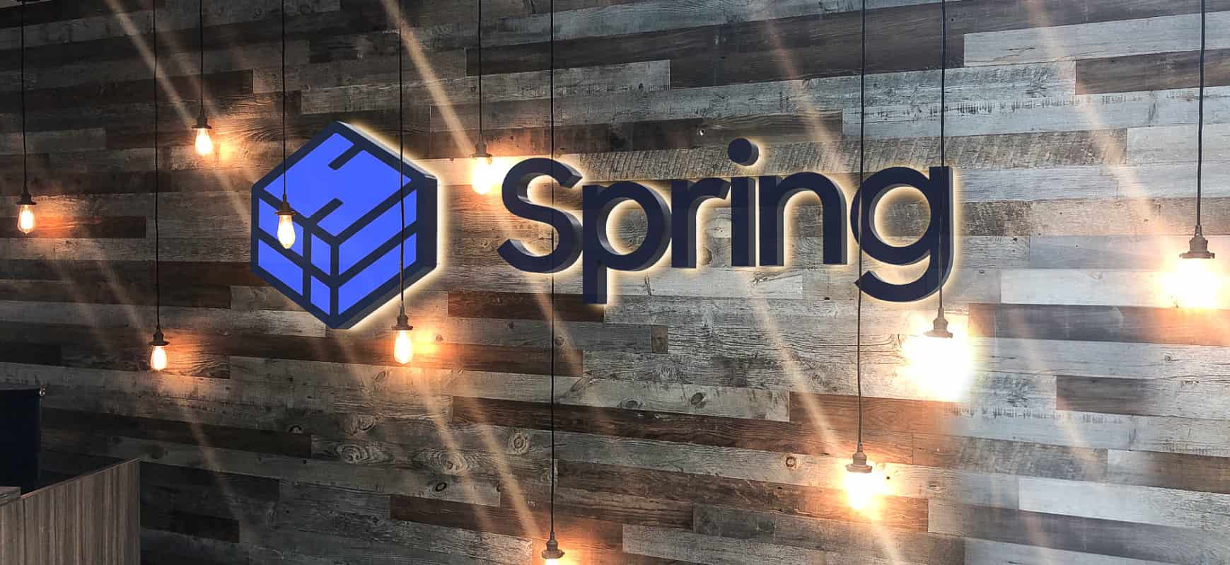 Spring modern signage design featuring the brand name and logo with backlit illumination