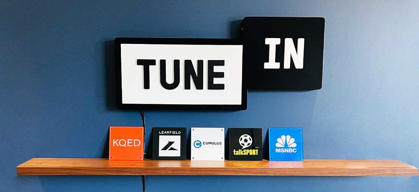 TuneIn trendy sign featuring the brand logo made of aluminum and acrylic for interior branding