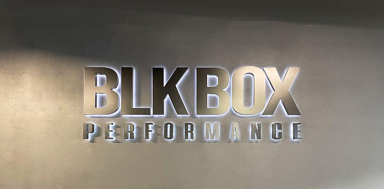 BLK BOX Performance backlit metal wall art displaying the company name for interior branding