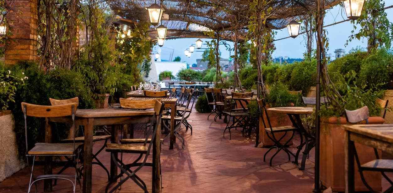 Outdoor restaurant decor trend with sustainable furniture and plants surrounding the area