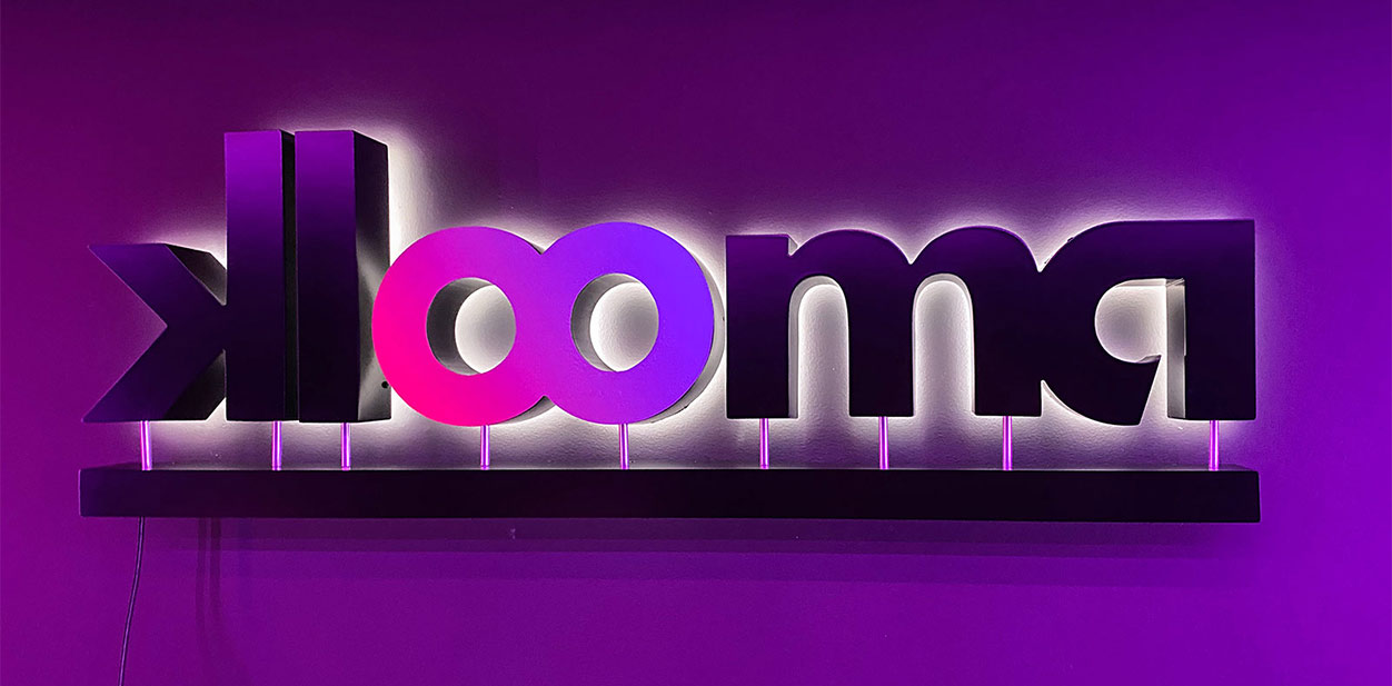 Klooma backlit accent wall showcasing the brand logo with modern lighting