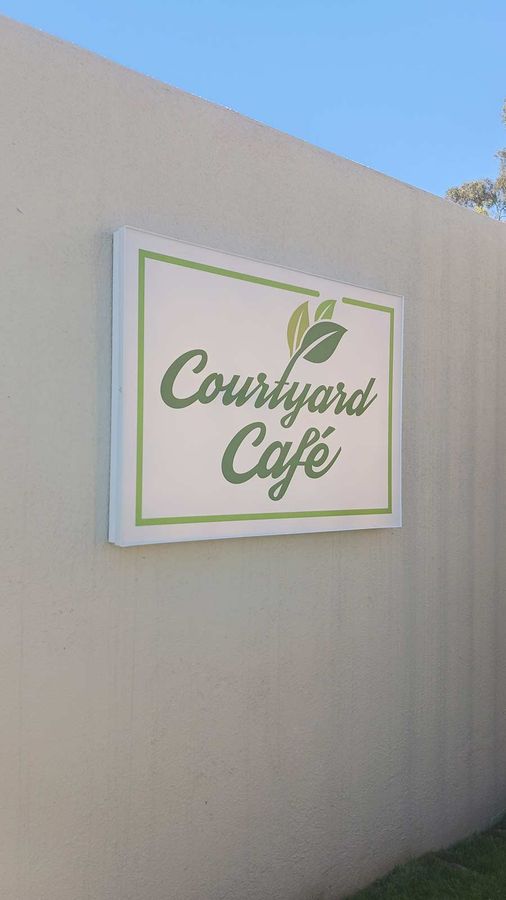 Courtyard Cafe light box sign attached to the exterior wall