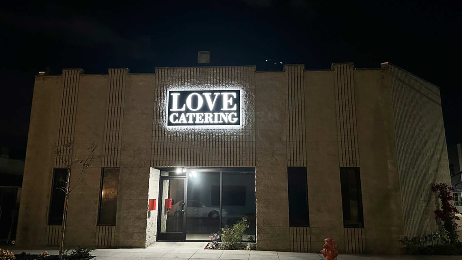 Love Catering, Inc. light box sign mounted on the facade