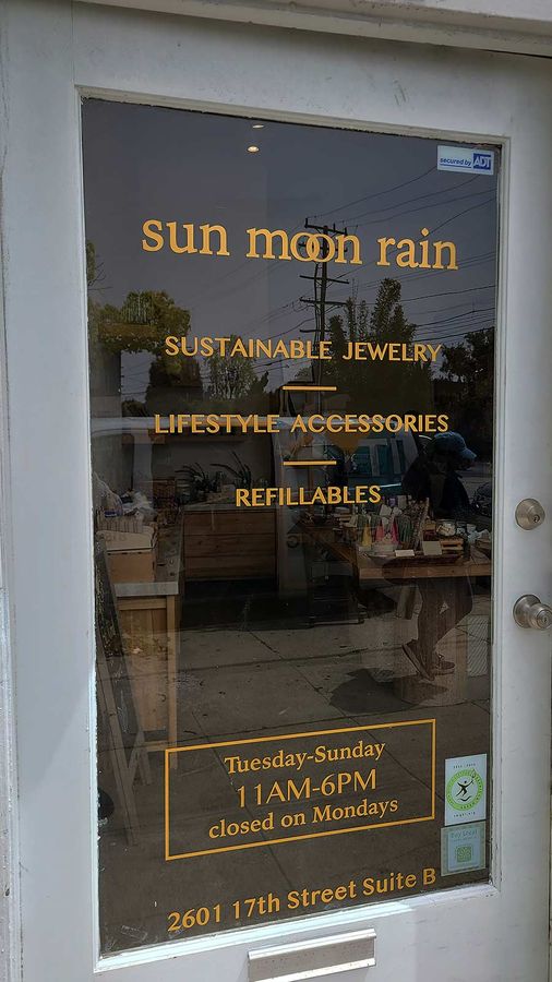 Sun Moon Rain vinyl lettering attached to the storefront