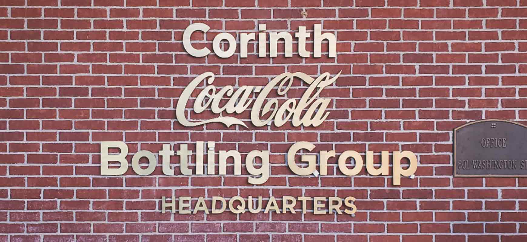 Coca-Cola custom wall sign reading the brand name made of brushed brass