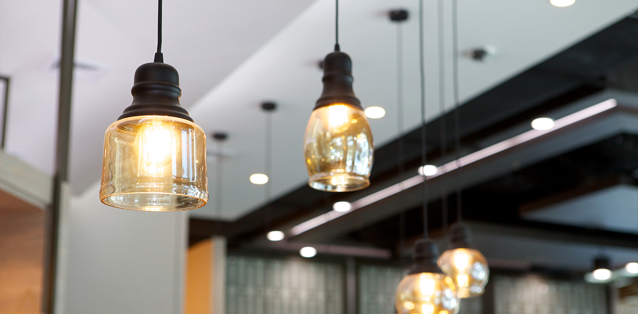 Modern retail interior design highlighted with yellow chandeliers hanging from the ceiling