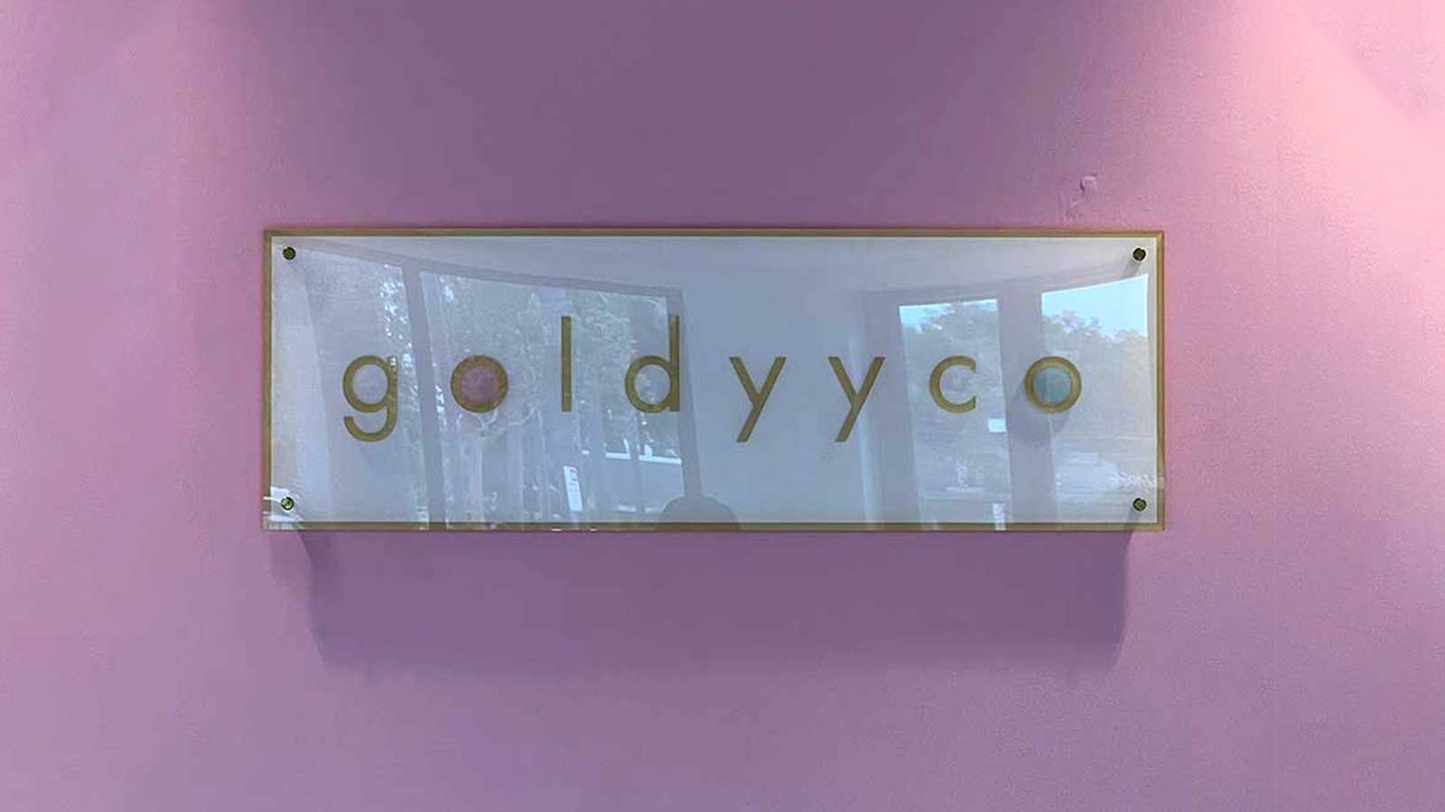 Goldyyco acrylic sign attached to the wall