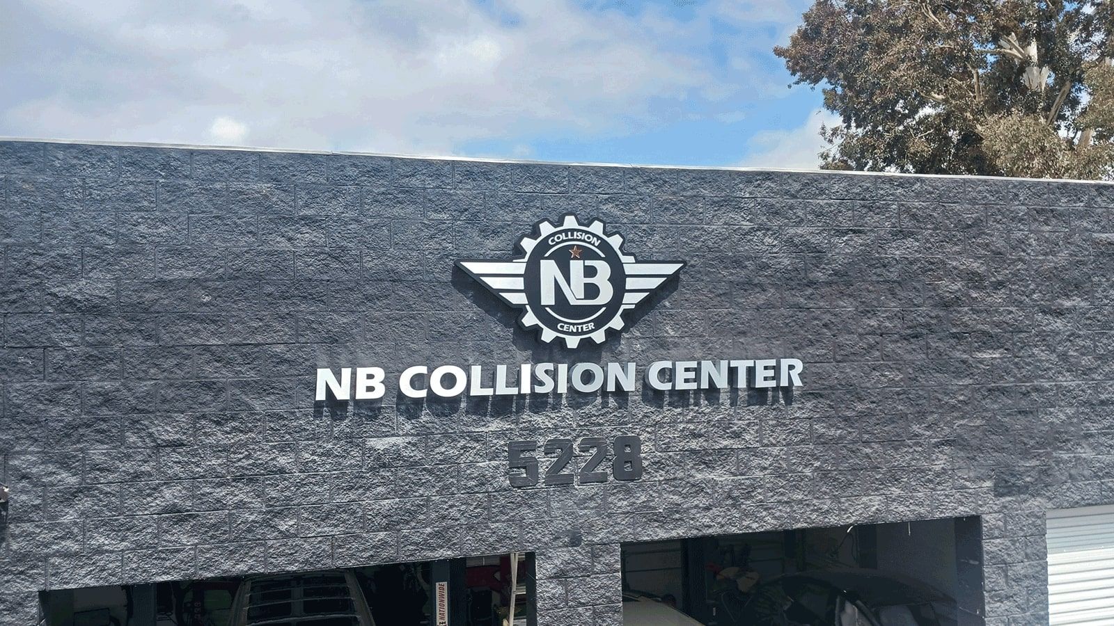 NB Collision Center light up signs set up on the facade