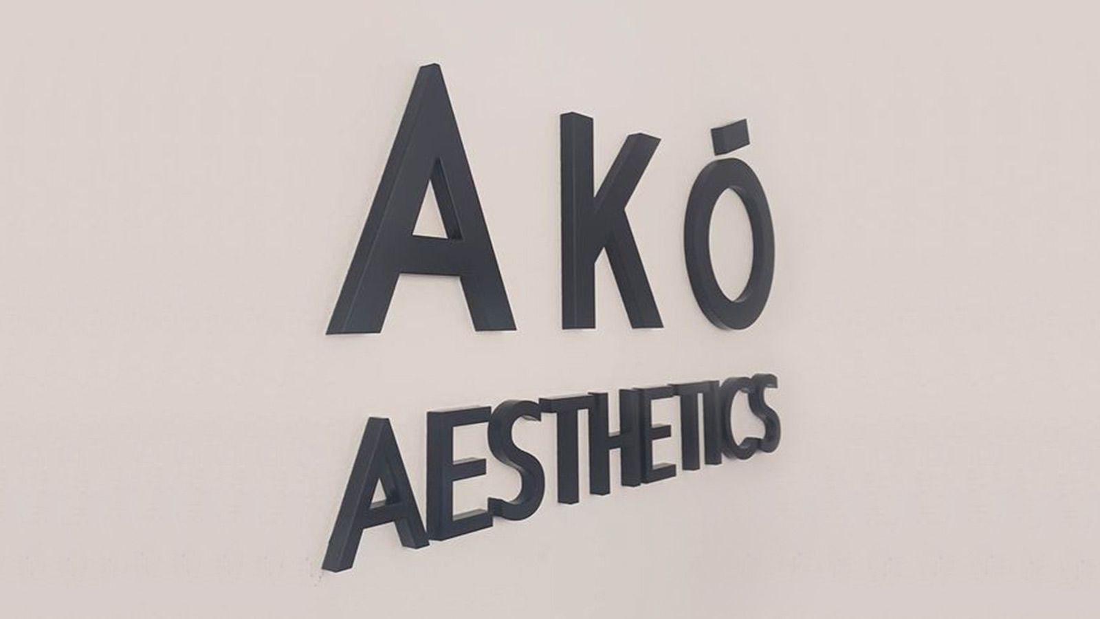 AKO Aesthetics lobby sign installed on the wall