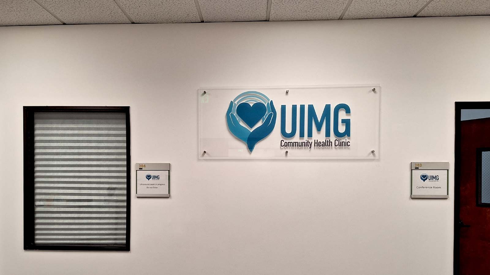 UIMG Community Health Clinic acrylic sign mounted on a wall