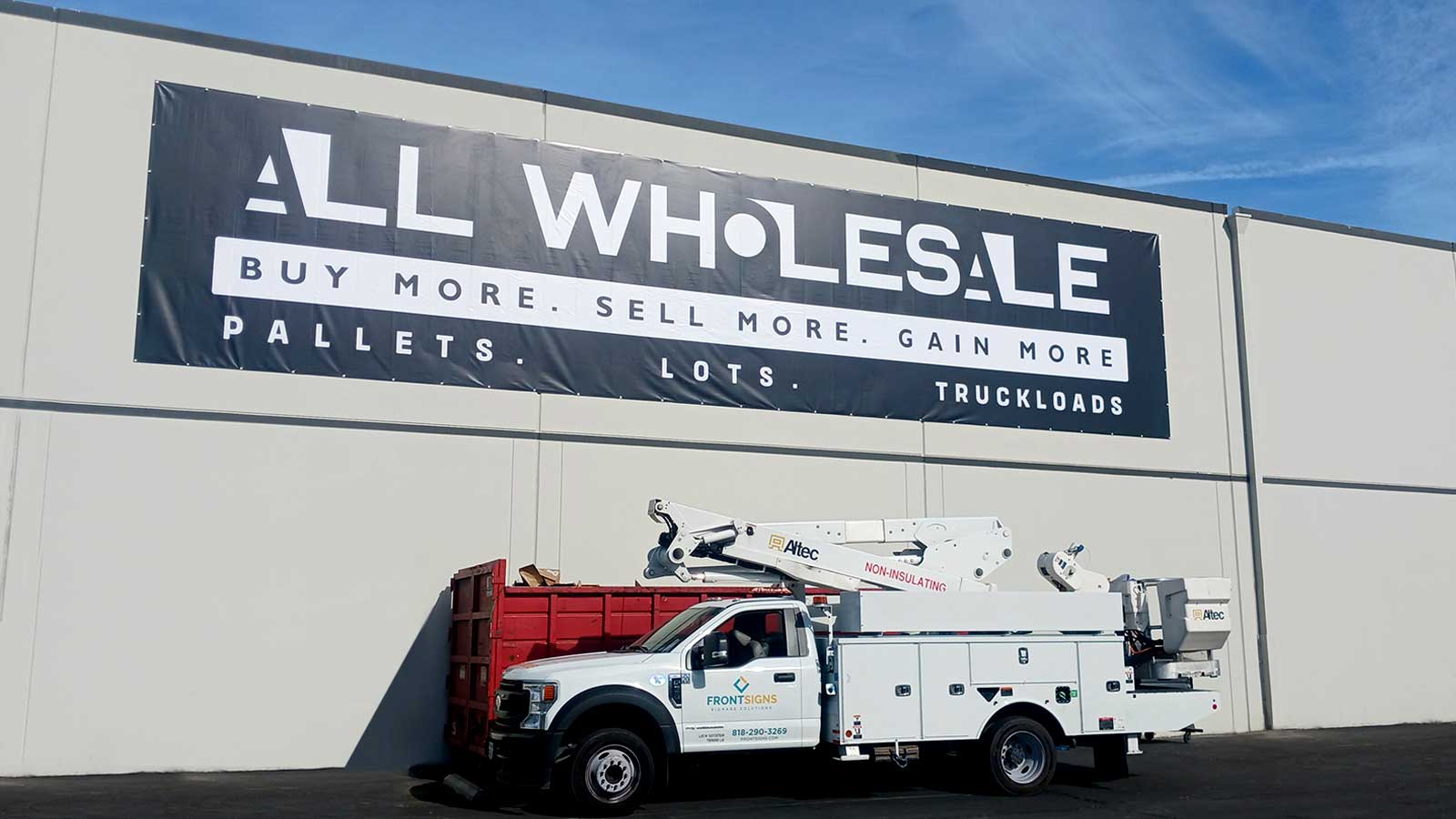 All Wholesale LLC banner installed on the exterior wall