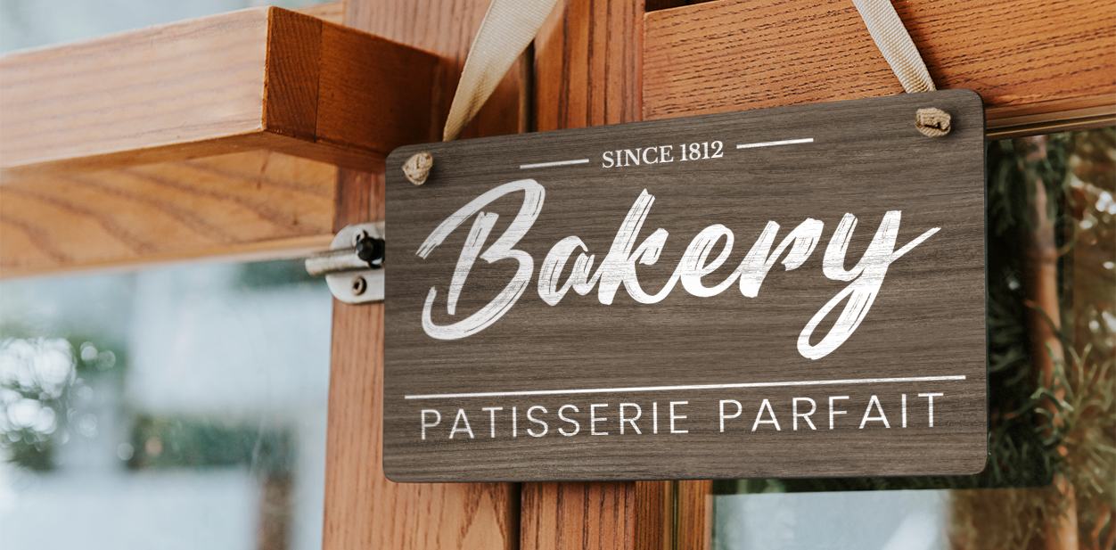 Rustic bakery signage design hanging from the window with company name