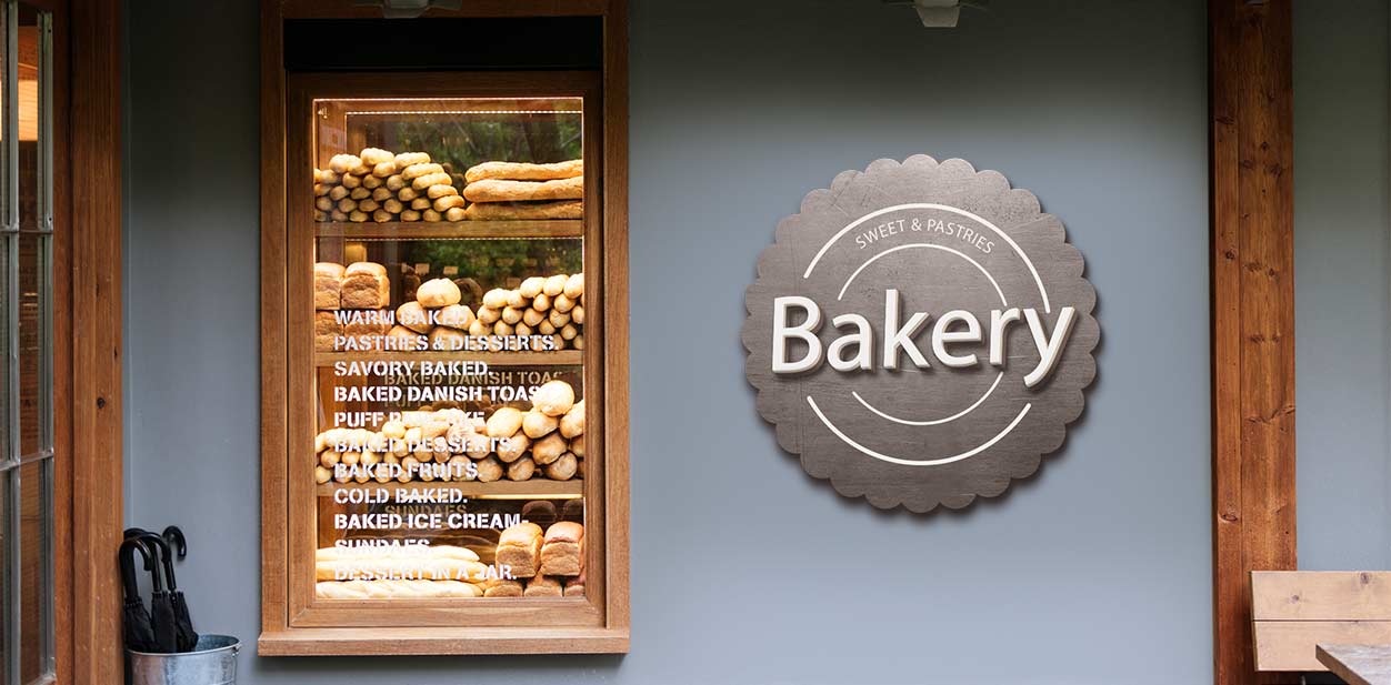 Dimensional bakery wall art featuring the word bakery mounted beside the pastry window.