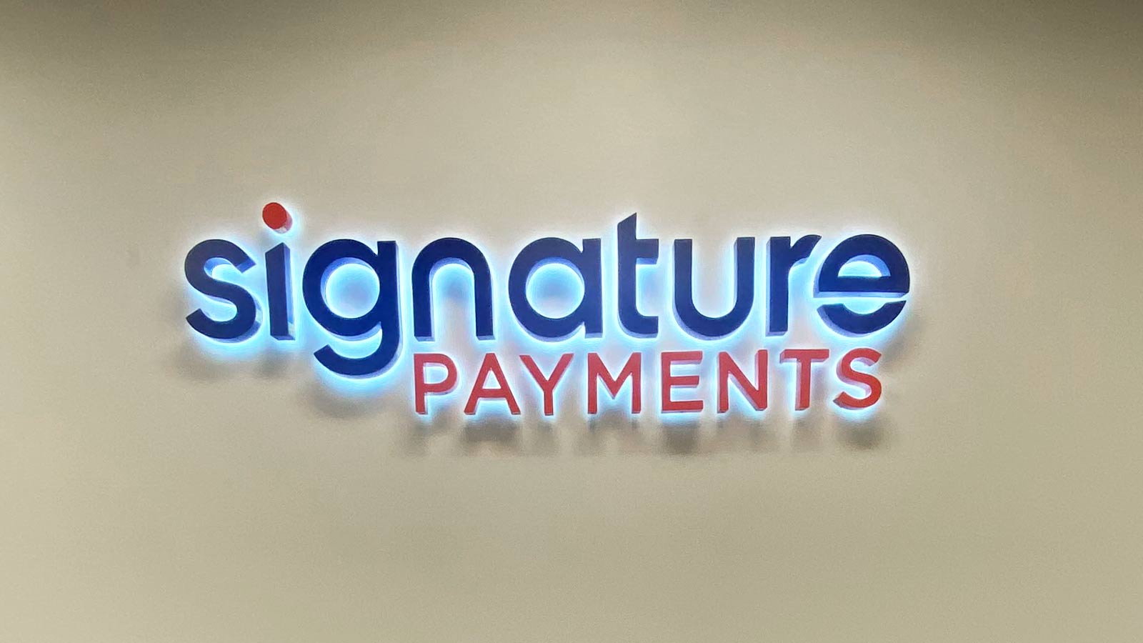 signature payments backlit channel letters mounted on a wall