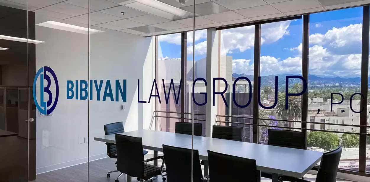 Modern law office design on glass featuring the company name in bold blue letters.