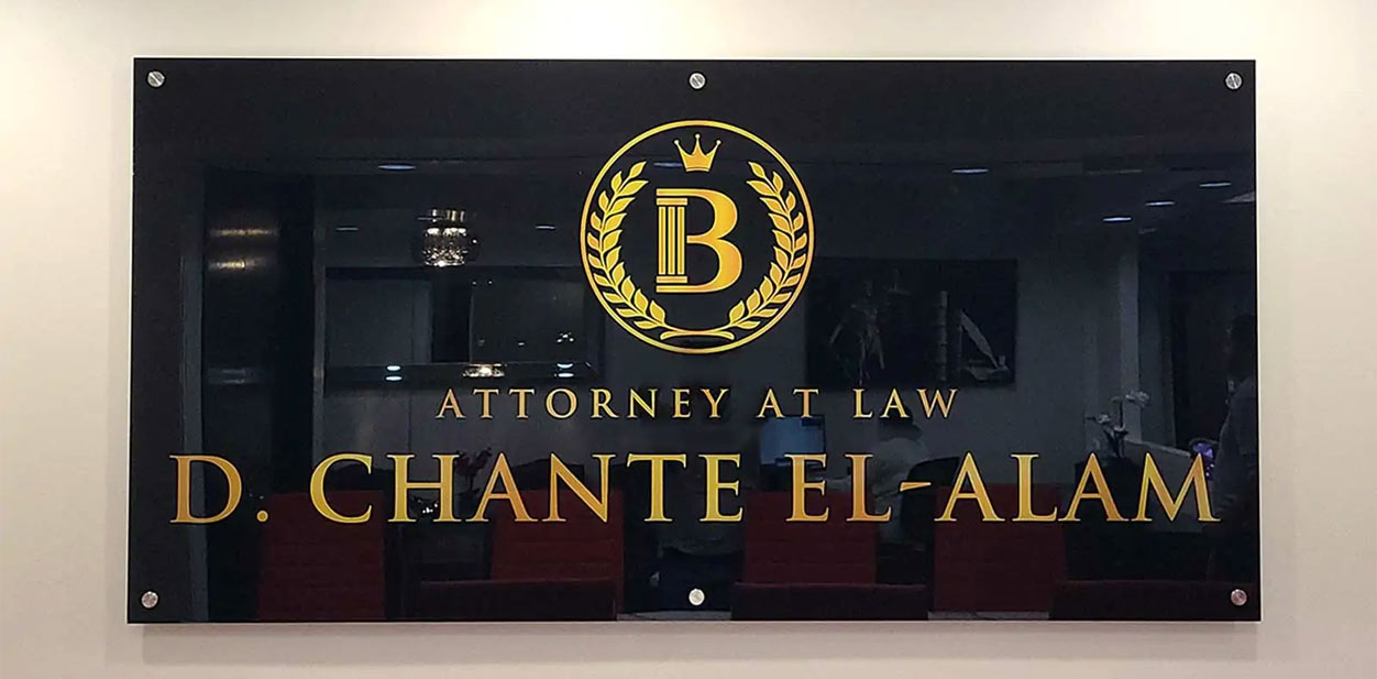 Transparent modern law firm design with the attorney’s name in gold on a black plaque.