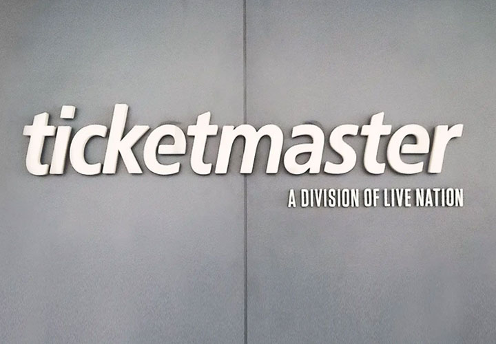 An indoor sign for Ticketmaster installed on a gray wall.