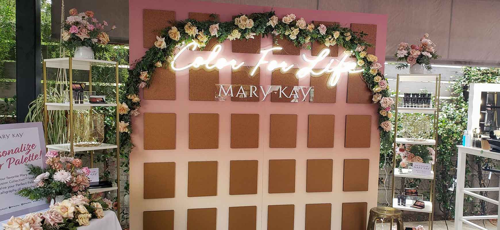 A pink and brown freestanding sign with a neon light and branded elements.