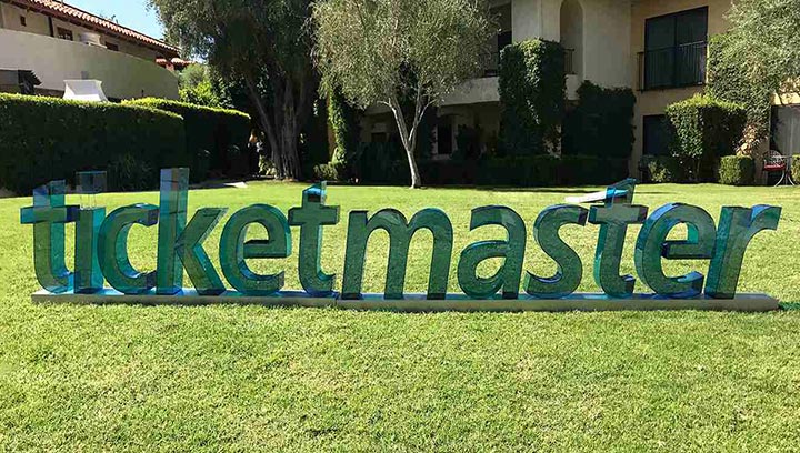 Acrylic freestanding sign with blue and green Ticketmaster logo letters.