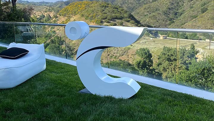 Freestanding aluminum sign in the shape of a letter 