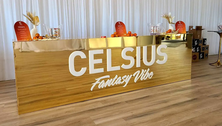Retail promotion freestanding sign with a gold finish and the Celsius and Fantasy Vibe logos.