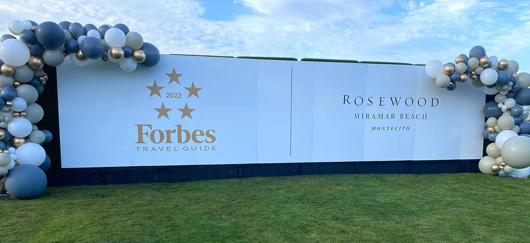 Large event freestanding sign with brand logos and a balloon arch.