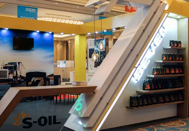 Trade show booth for S-Oil featuring a display of motor oil on lighted shelves.