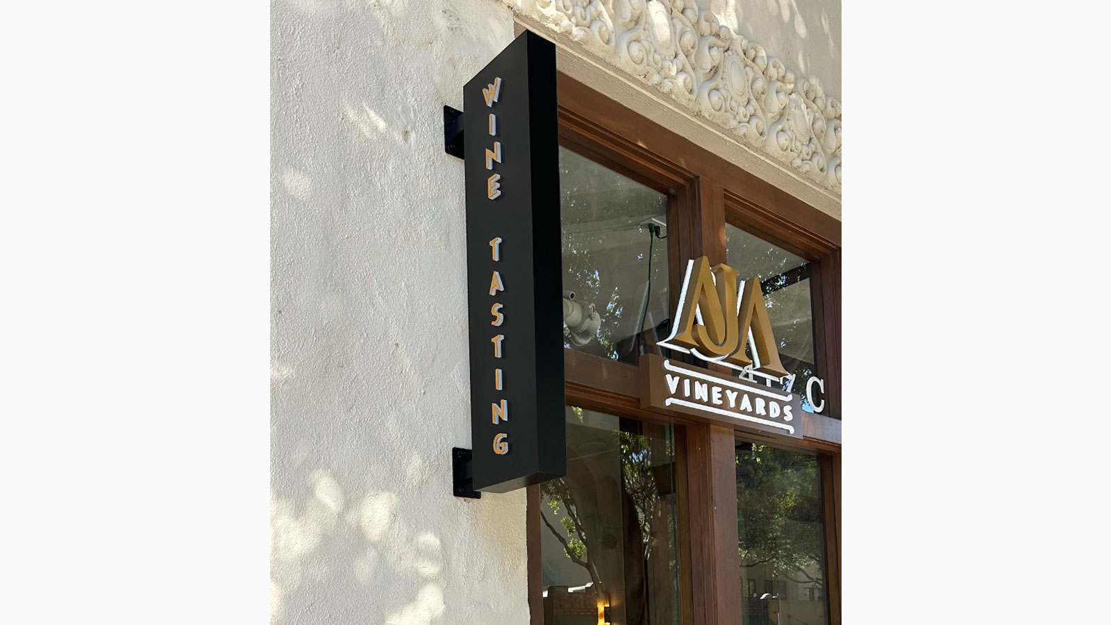 aja vineyards illuminated blade sign hung on storefront