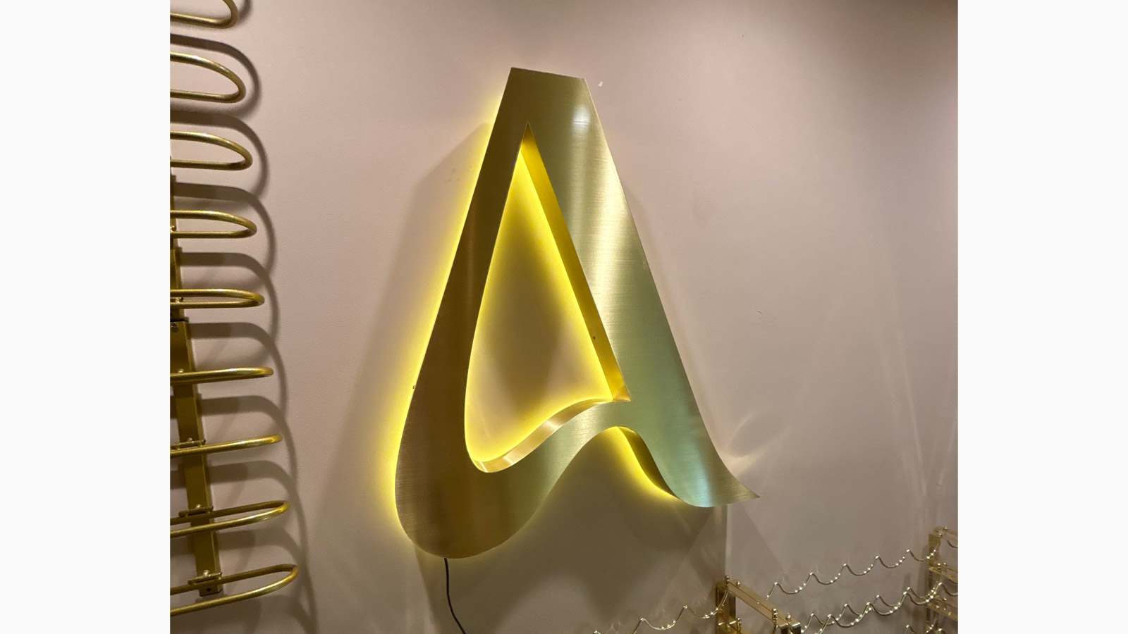azur back lit brass channel letter mounted on wall
