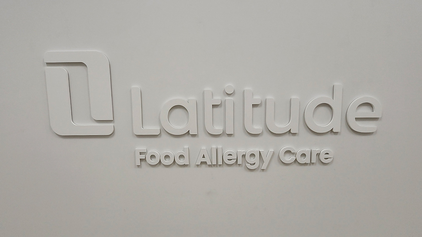 latitude food allergy care acrylic logo on office wall