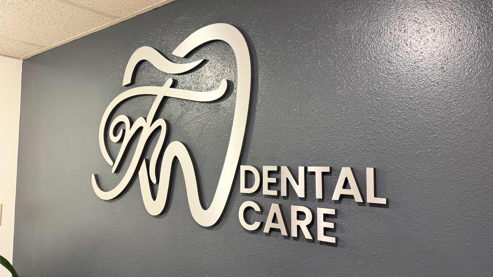 mt dental care logo sign mounted on wall