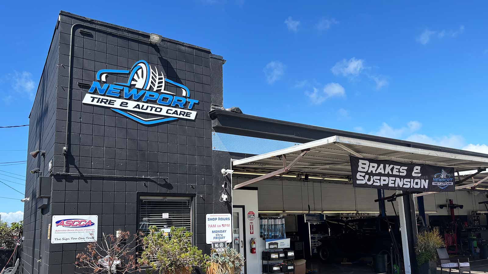 newport tire and auto care acrylic sign mounted on building
