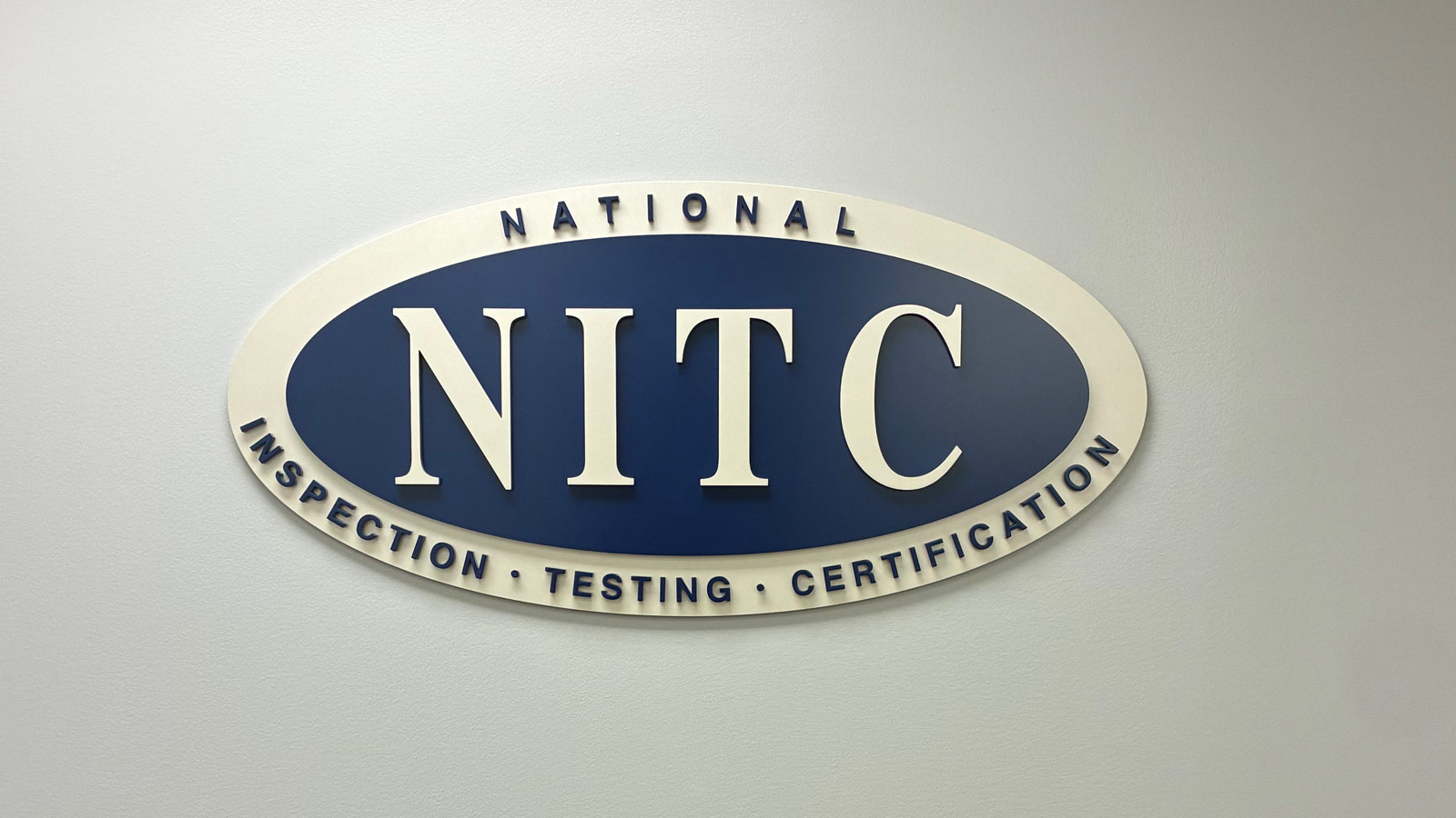 nitc layered acrylic logo sign mounted on office wall