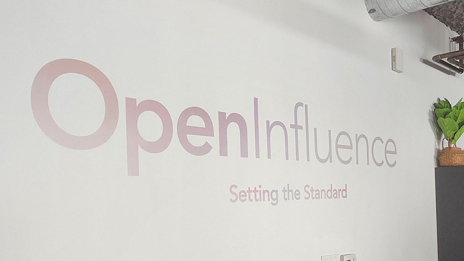 open influence vinyl decal with tagline applied on wall