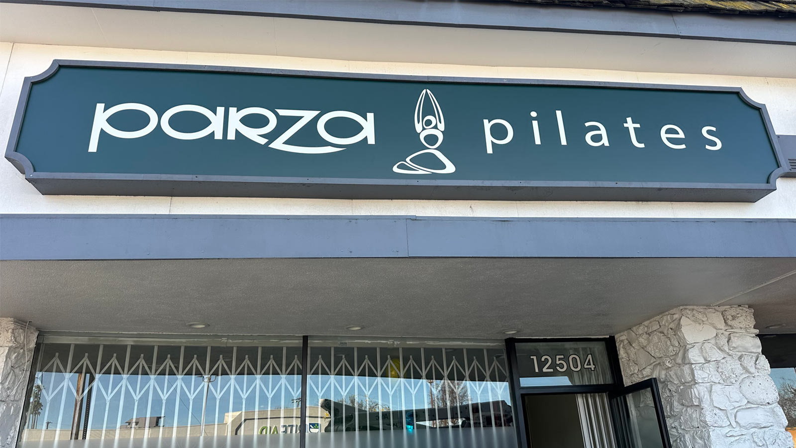 parza pilates illuminated storefront sign on facade