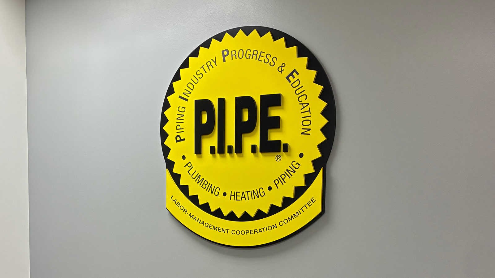 pipe layered acrylic logo sign mounted on office wall