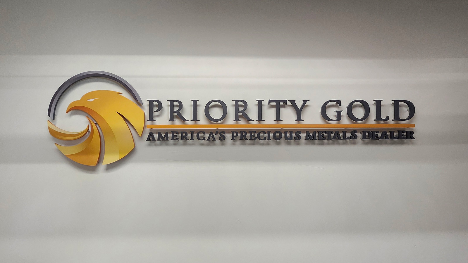 priority gold acrylic logo and letters on office wall