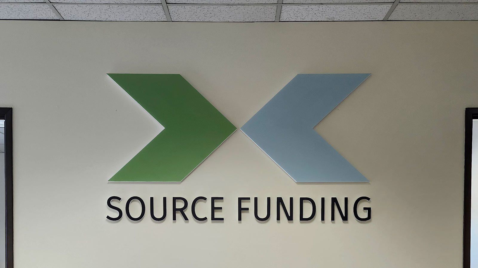 source funding gator board sign mounted on office wall