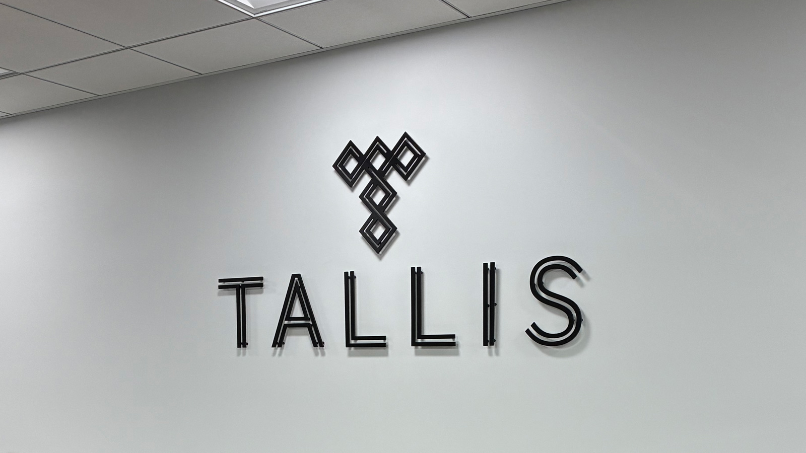 tallis aluminum logo and letters on office wall