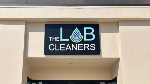 the lab cleaners push through sign on storefront wall