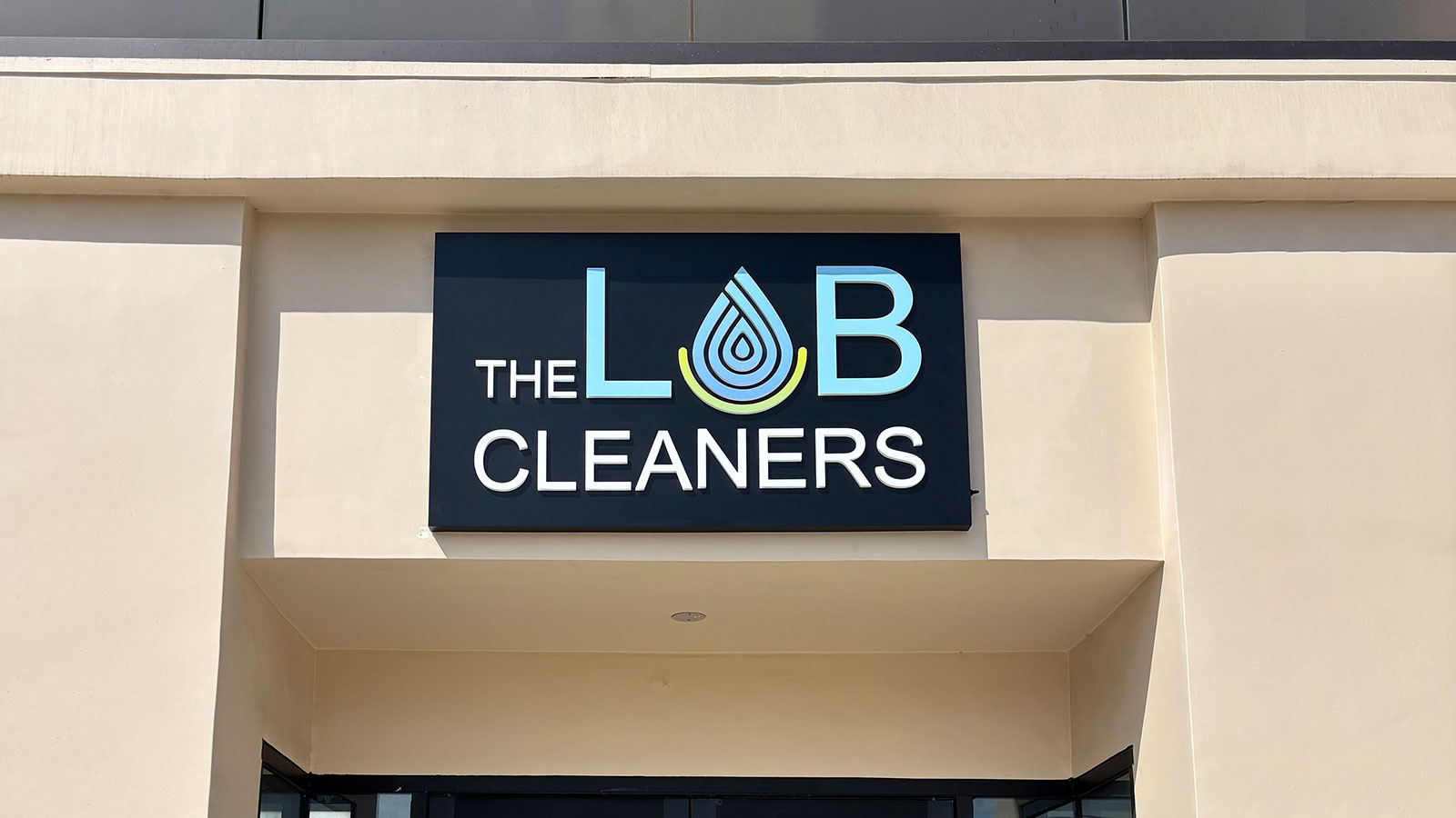 the lab cleaners push through sign on storefront wall