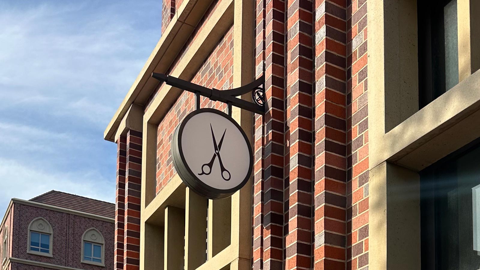 the salon usc village blade sign mounted on the wall