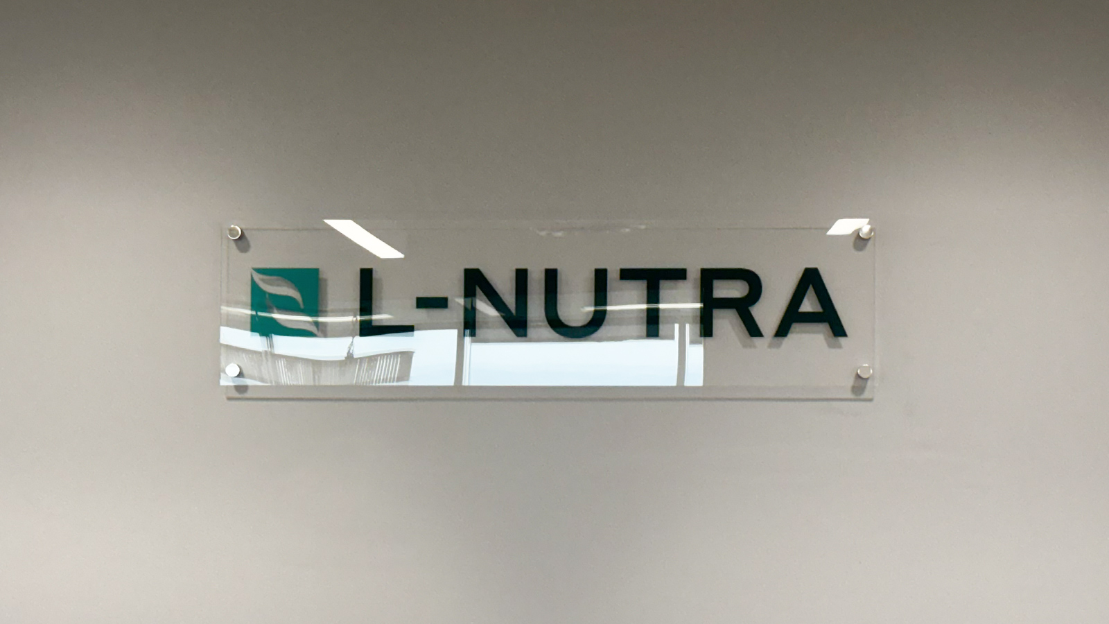 l nutra clear acrylic sign on wall