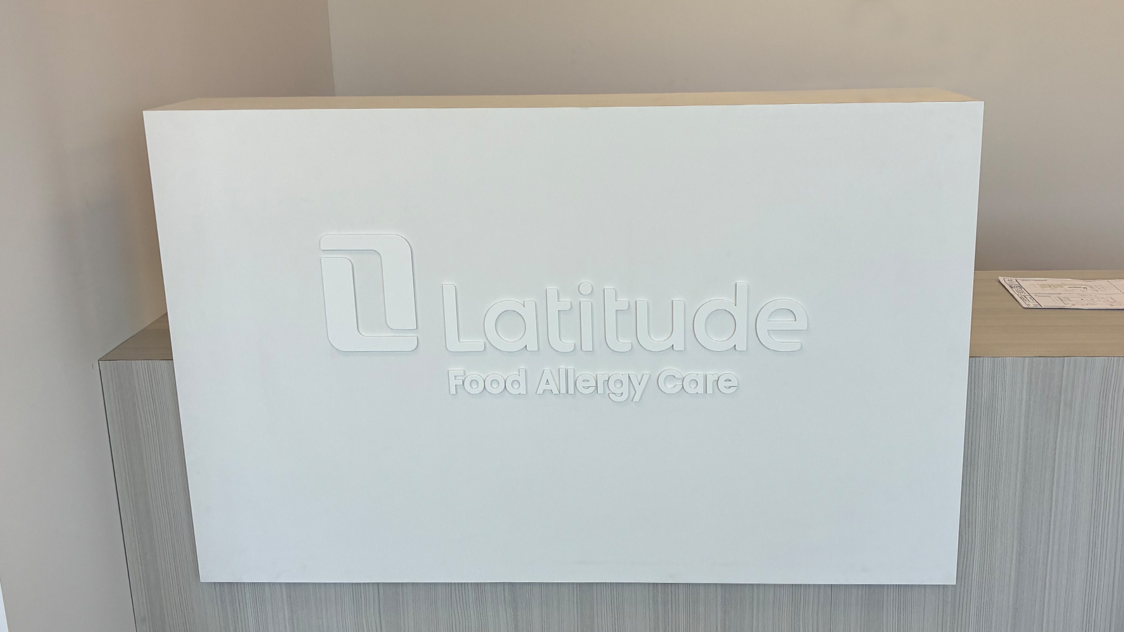 latitude painted acrylic letters on reception desk
