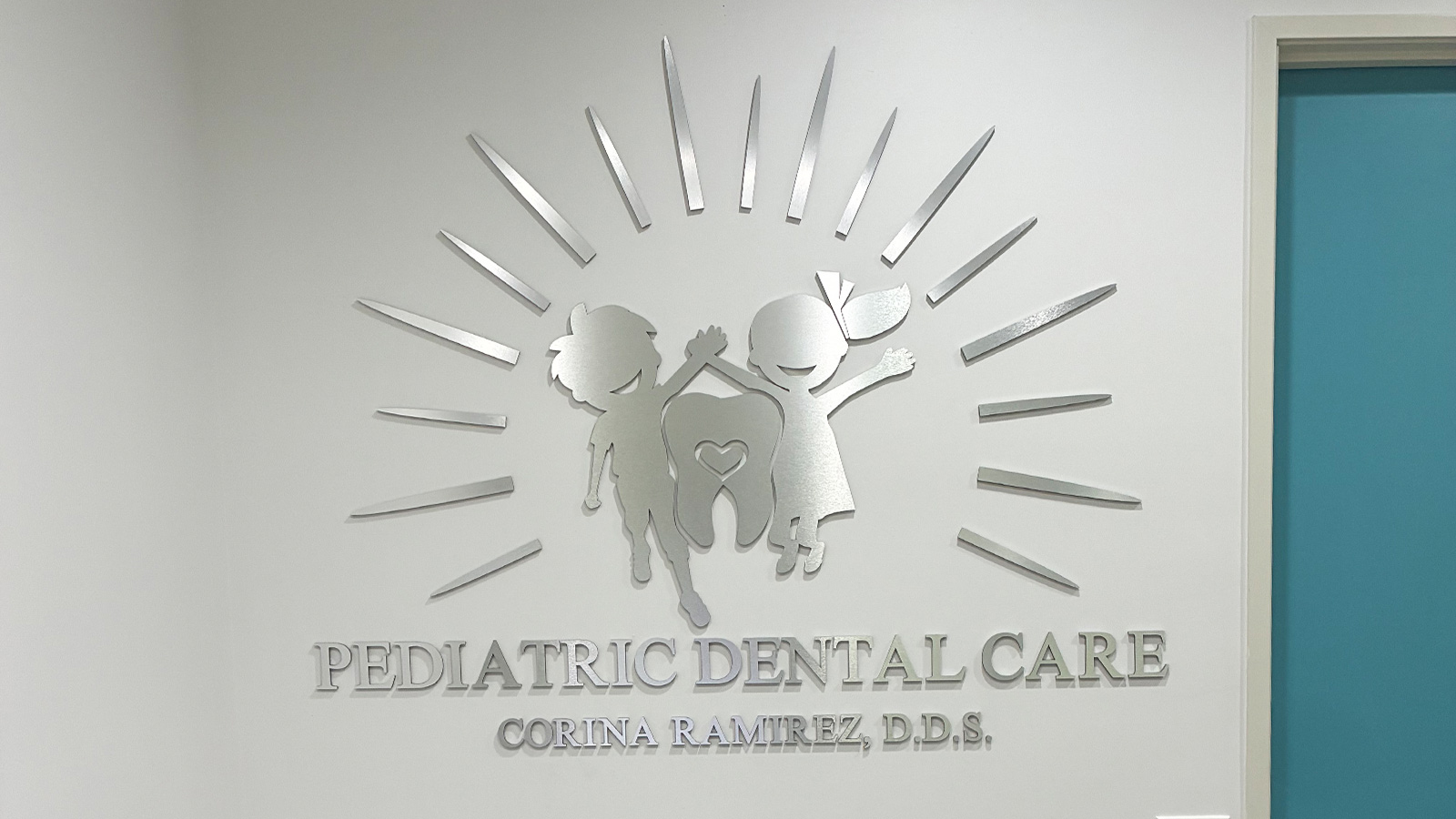 pediatric dental care brushed aluminum letters on lobby wall