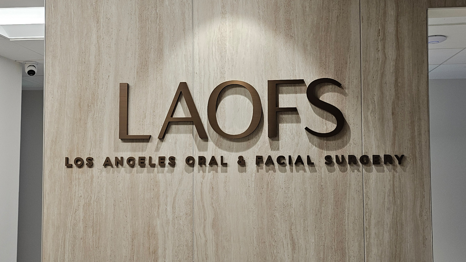 simour design brass dimensional letters on wooden wall