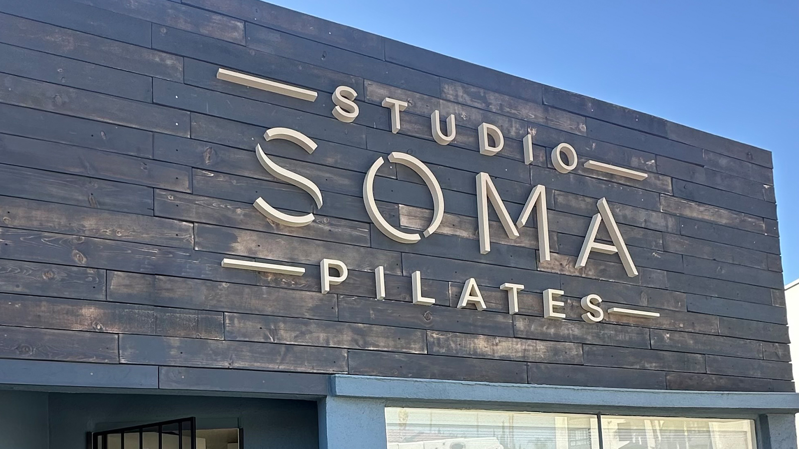 studio soma pilates hdu letters on wood facade